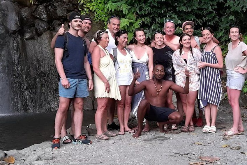 Eine Gruppe von Personen posiert vor einem felsigen Wasserfall. 1