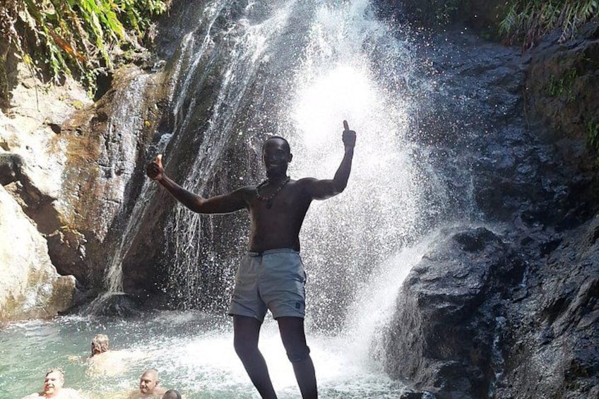 Eine Person steht vor einem Wasserfall, Wasser stürzt herunter. 3
