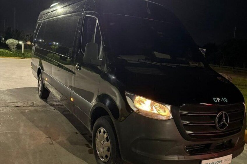 A black Mercedes-Benz Sprinter van parked at night. 3