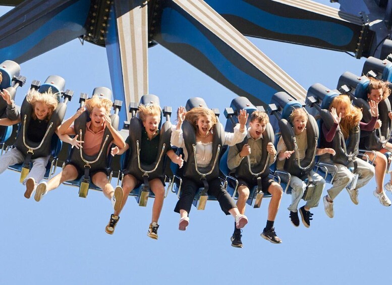 A group of people on a roller coaster in mid-air. 5