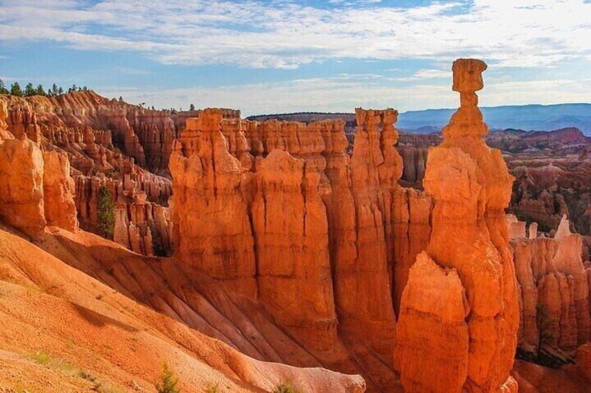 A landscape of red rock formations with a prominent spire-like structure. 3