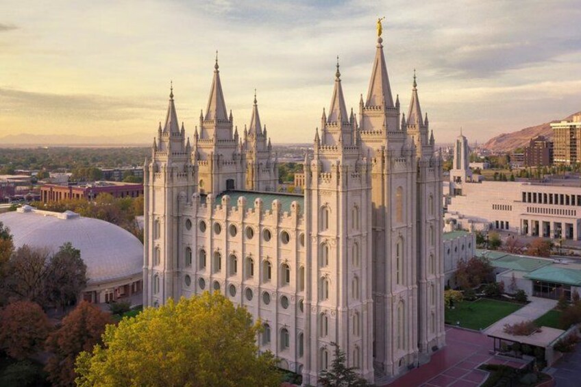 A large, ornate cathedral with multiple spires and a dome, surrounded by urban buildings and trees. 3