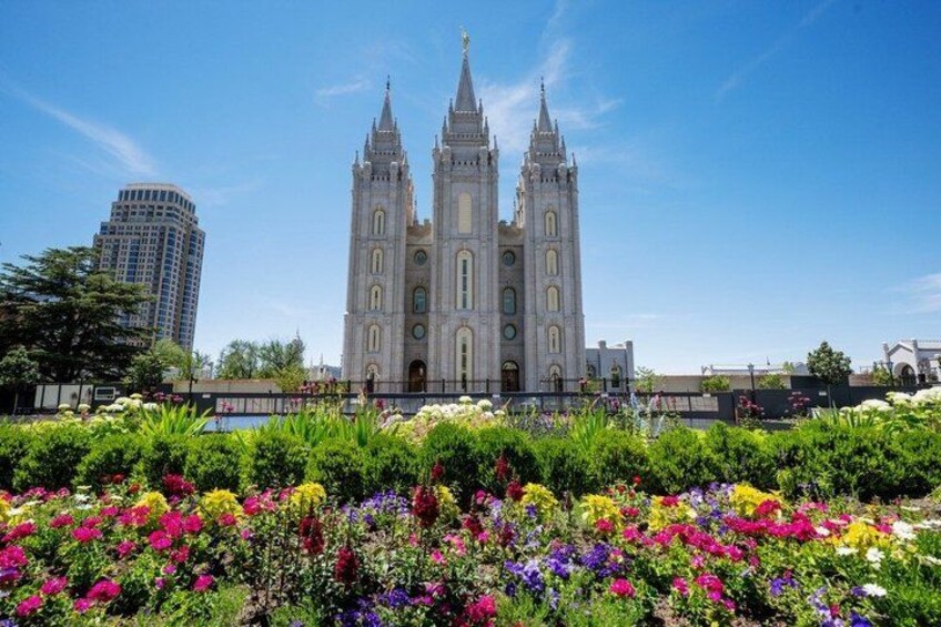 A historic cathedral with twin towers, surrounded by a vibrant garden with various colorful flowers. 2