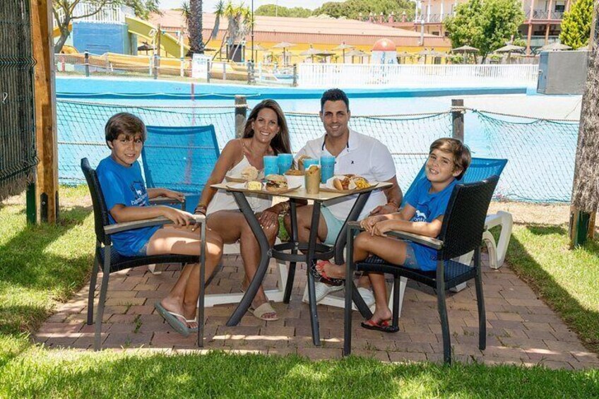 A family dining at an outdoor table by a poolside. 3