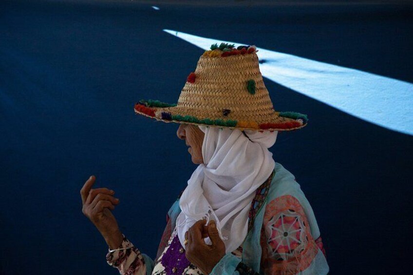 A person wearing a colorful hat and a patterned garment. 4