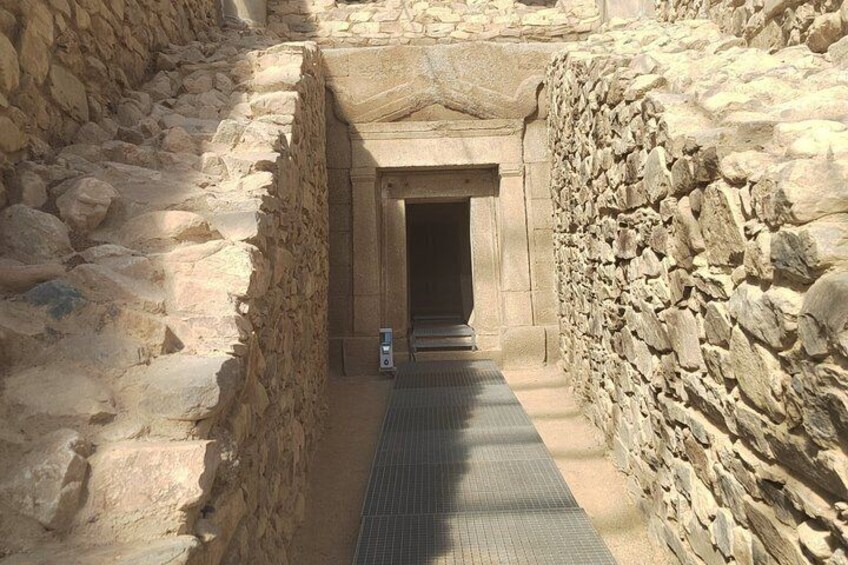 A narrow stone passageway leading to an ancient doorway. 4