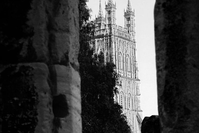 A Gothic-style cathedral with intricate spires and detailed stonework, viewed through a stone archway. 2