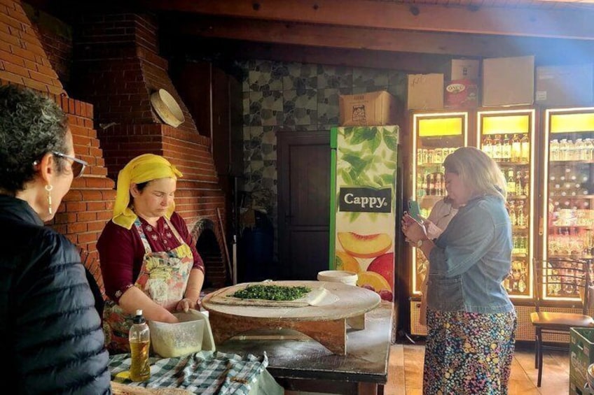 A person using a smartphone, a brick oven, and a Cappy sign in a cafe setting. 2