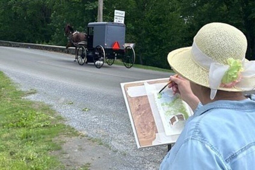 A person painting a landscape with a horse-drawn carriage in the background. 5