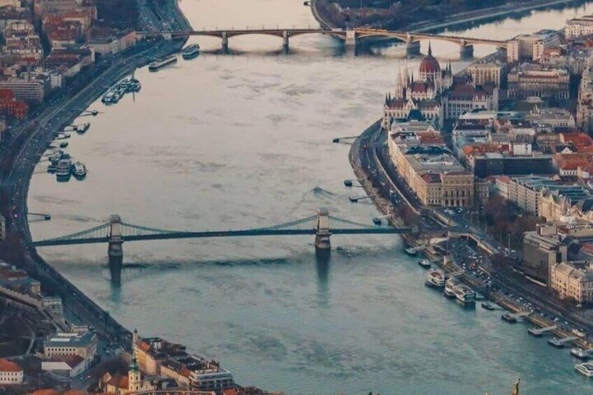 A river with bridges, boats, and buildings along the banks. 5