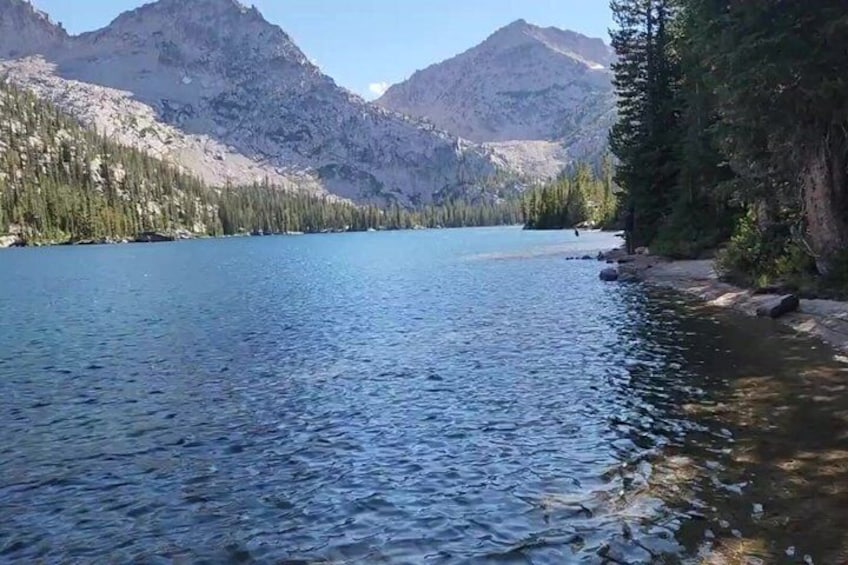 A calm lake surrounded by mountains and dense forest. 4