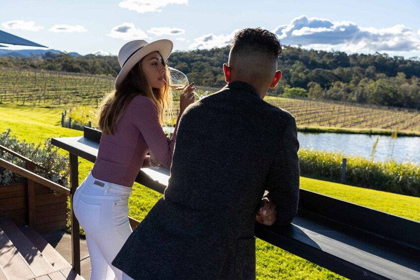 A couple overlooking a vineyard with a lake in the background. 1