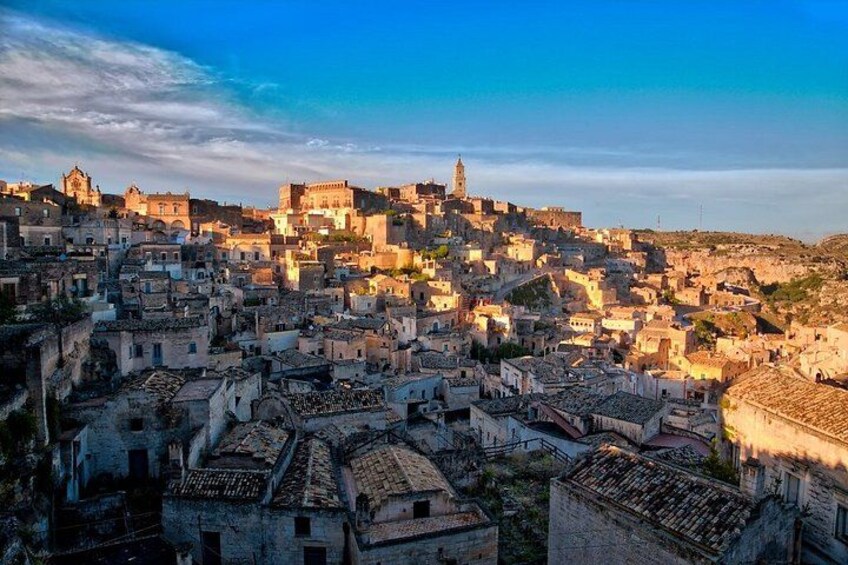 A densely packed historic town with numerous buildings, a prominent church, and a hilltop fortress. 2