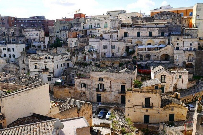 A densely packed urban area with historic buildings, narrow streets, and a hilly terrain. 3