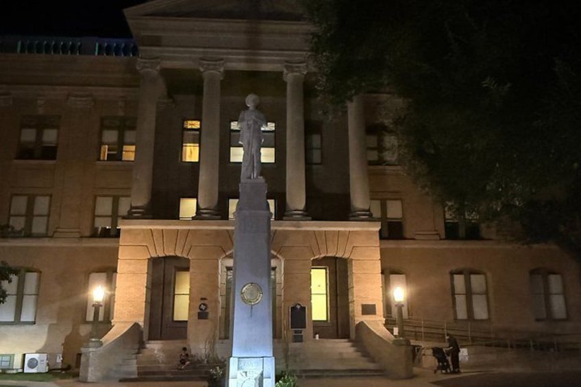 A classical building with columns and a statue in front. 5