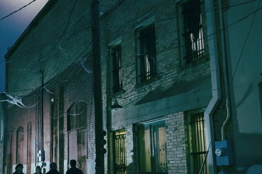 A brick building with barred windows and a streetlight. 3