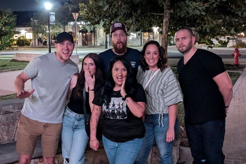 A group of people standing outdoors at night. 5