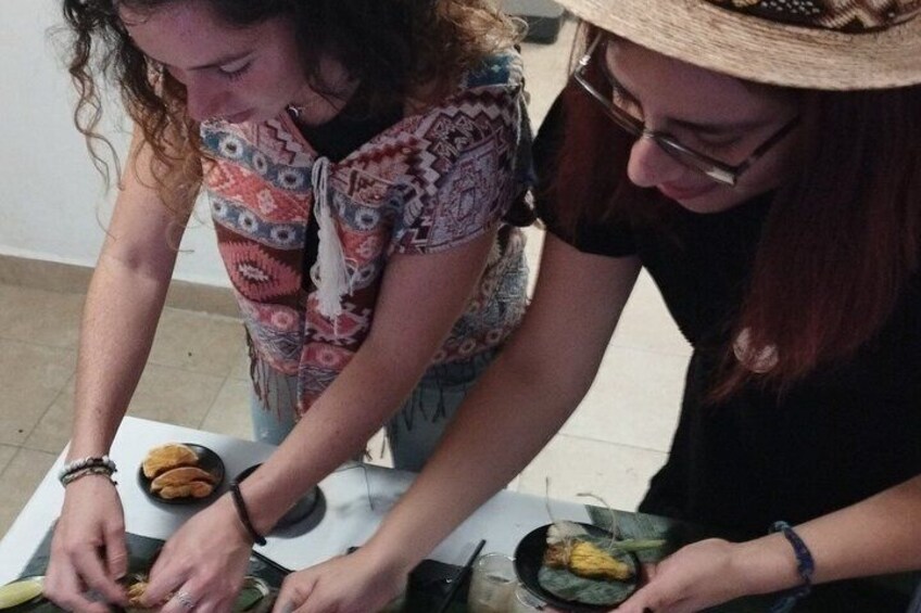 Two people preparing food, possibly a meal, with vegetables and a bowl on the table. 5