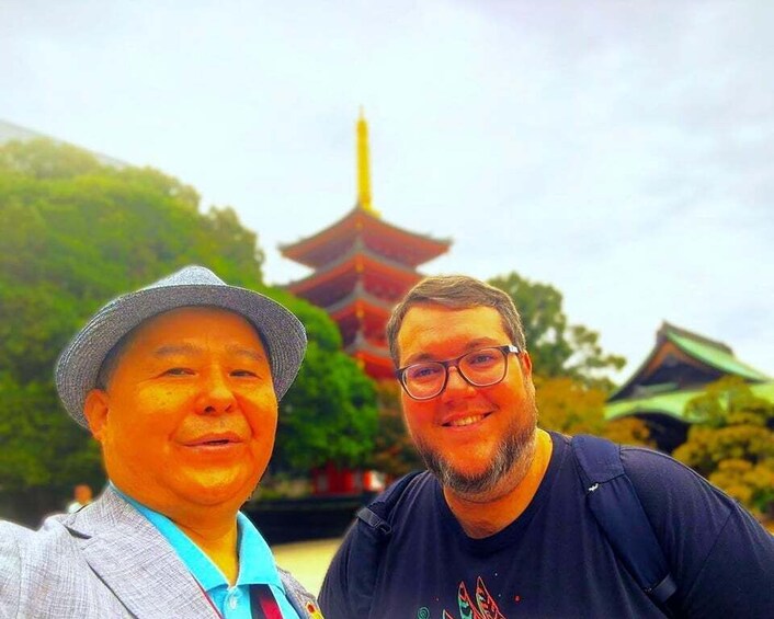 Two people in front of a pagoda-style building. 1