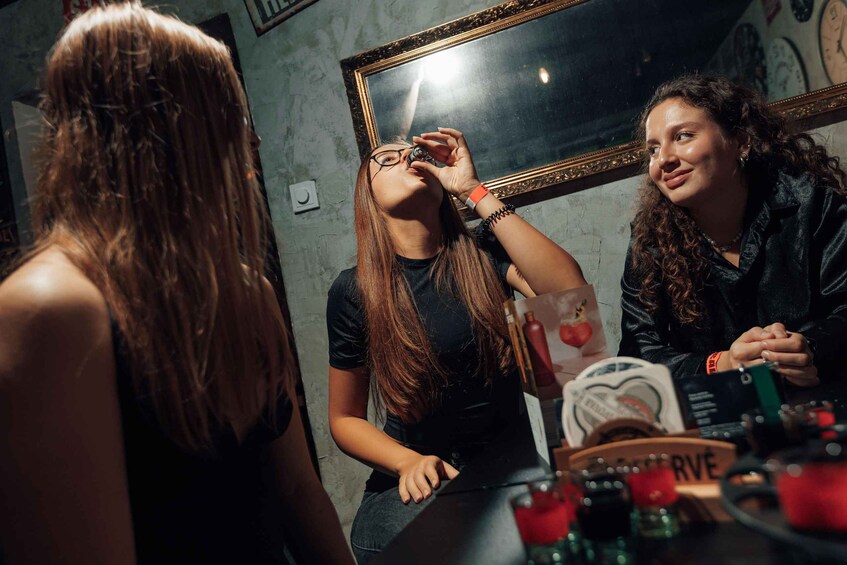 A person taking a selfie with a mirror reflection, a bottle, and a sign that reads 'RESERVE' in a dimly lit room. 2