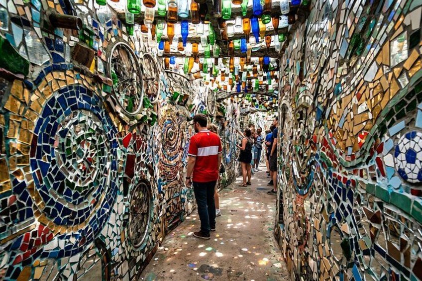 Un callejón estrecho con paredes cubiertas de coloridos mosaicos. 4