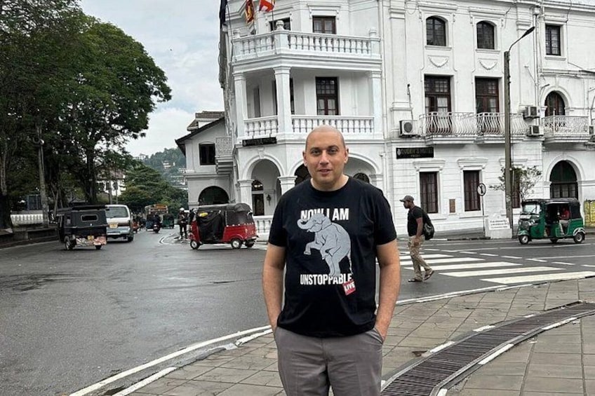 A man standing on a sidewalk with a building in the background. 5