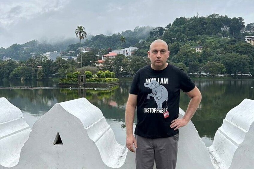 A man standing by a lake with a mountainous backdrop. 3