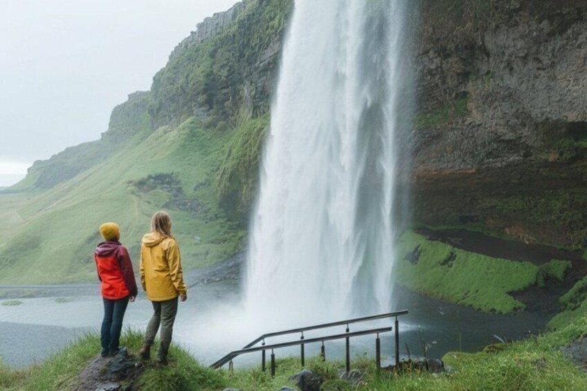 Two people standing by a waterfall with a river below. 4
