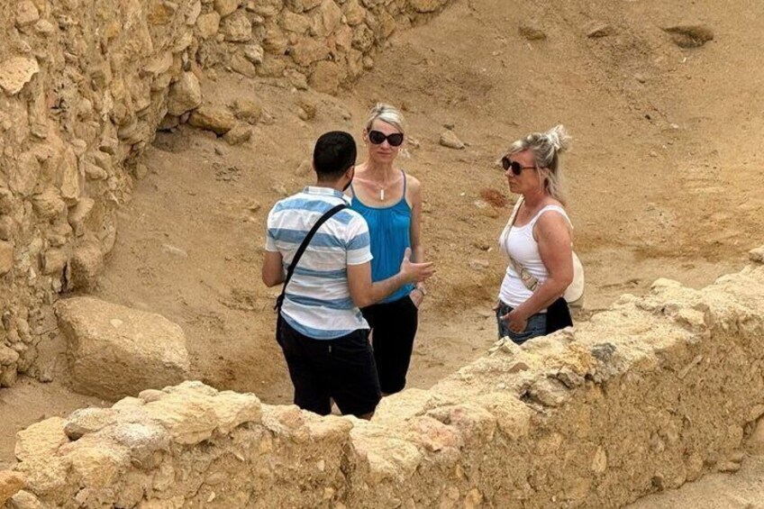 Three people standing near an ancient stone wall. 5