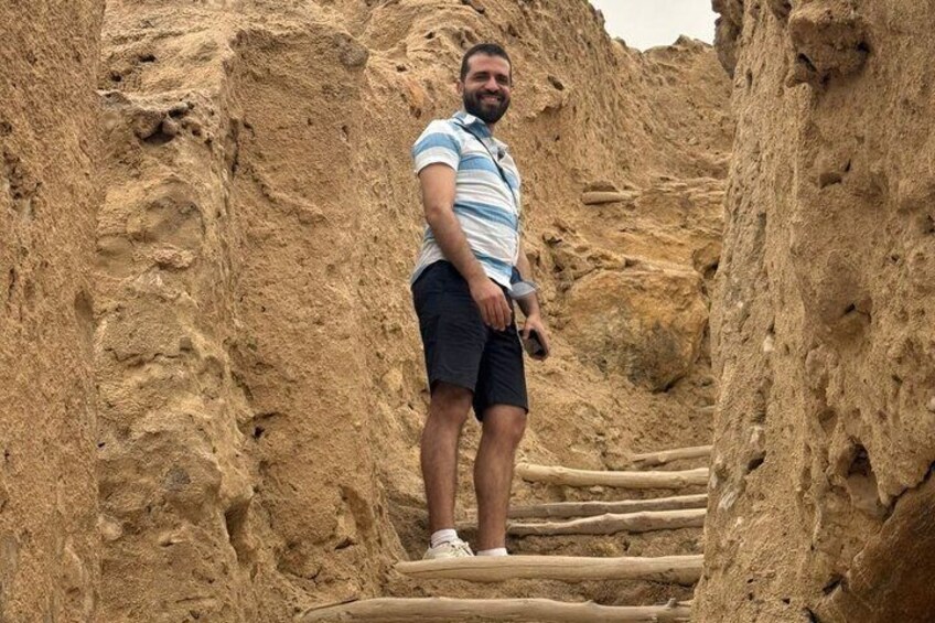 A person standing on a wooden staircase in a rocky terrain. 3