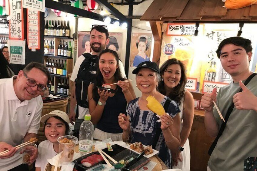 A group of people dining at a restaurant with various dishes and drinks on the table. 1