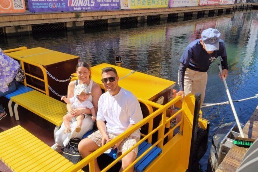 A family on a yellow dock with a person cleaning the water. 2