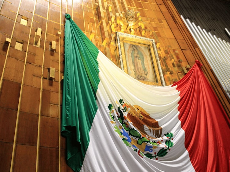 A flag with green, white, and red colors, and a mural with a religious figure. 5