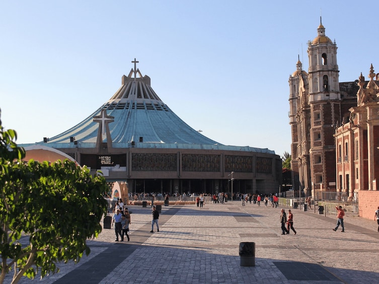 A large plaza with a prominent church featuring a cross on its roof and a bell tower. 4