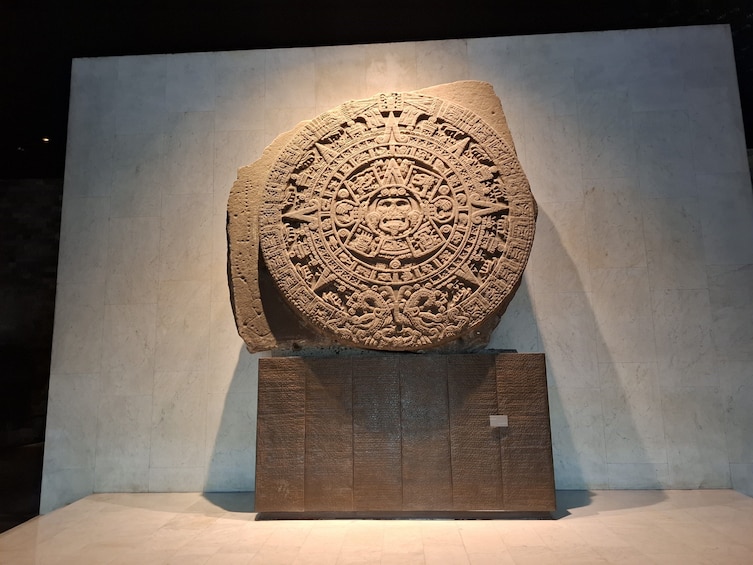 Un grand artefact en pierre, finement sculpté, exposé sur un piédestal dans un musée. 4