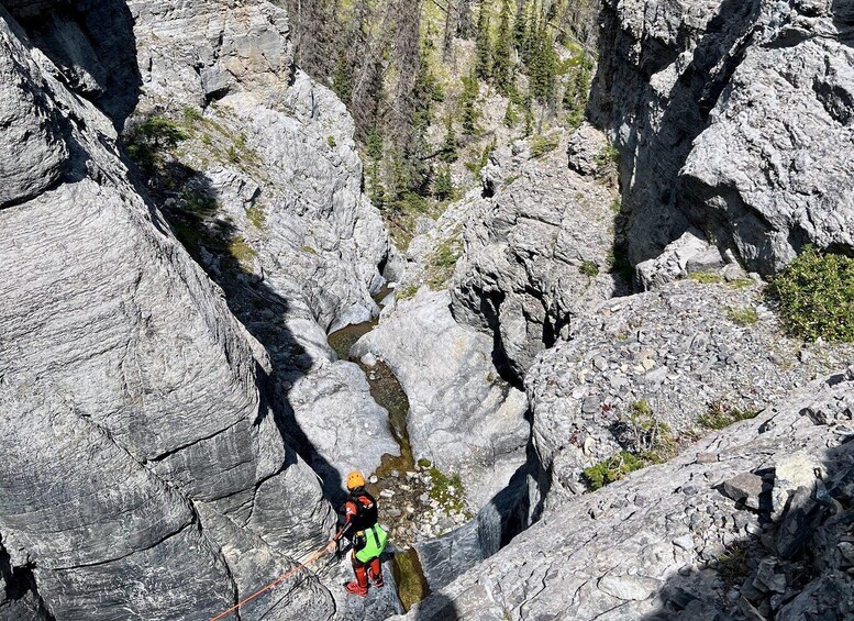 A person rappelling down a rocky cliff. 3