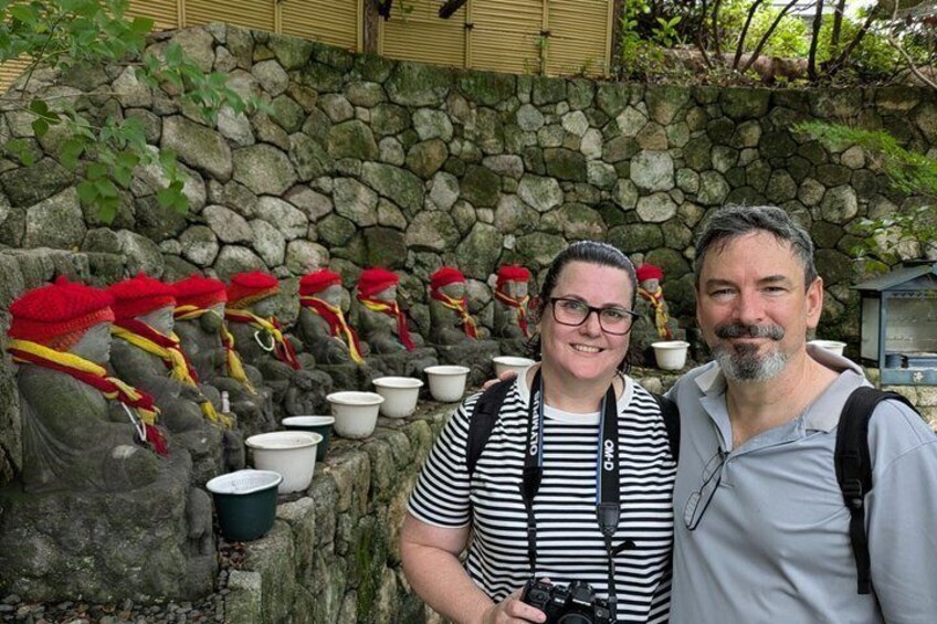 A stone wall with multiple white buckets and red hats. 3