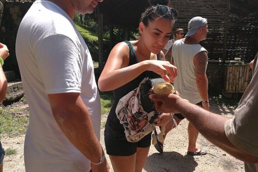 People outdoors, one person holding a coconut. 5