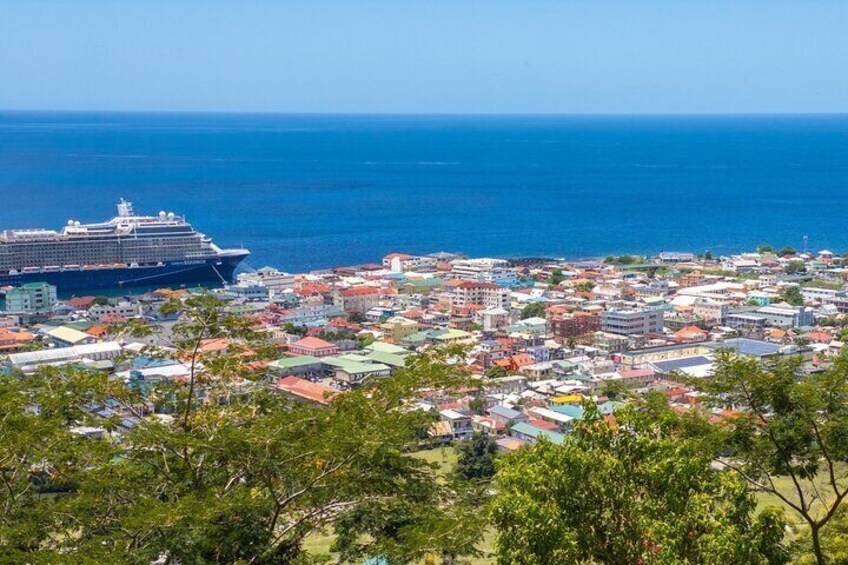A cruise ship in the ocean, a coastal town with colorful buildings, and a clear blue sky. 4