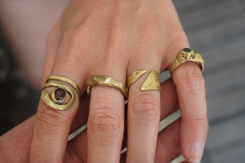 A hand with multiple rings on the fingers. 1