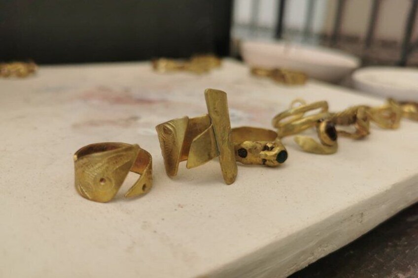 A collection of gold rings on a workbench. 2