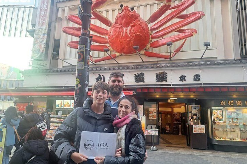 A street with a large red crab decoration above a building with Japanese signage. 2