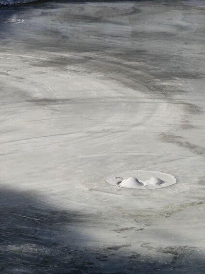 A frozen lake with a hole in the ice. 3