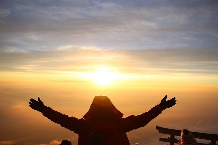 A person with arms outstretched against a sunset sky. 3