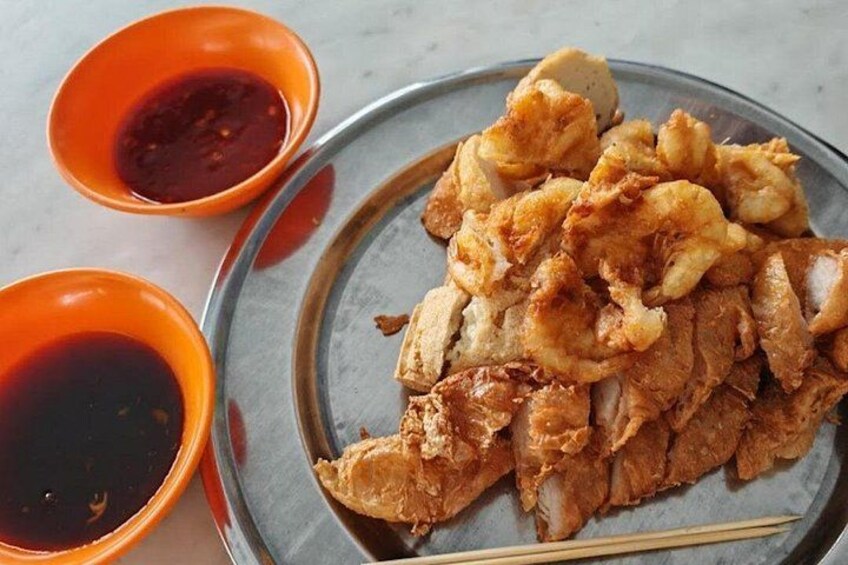A plate of fried food with two small bowls of sauce. 4