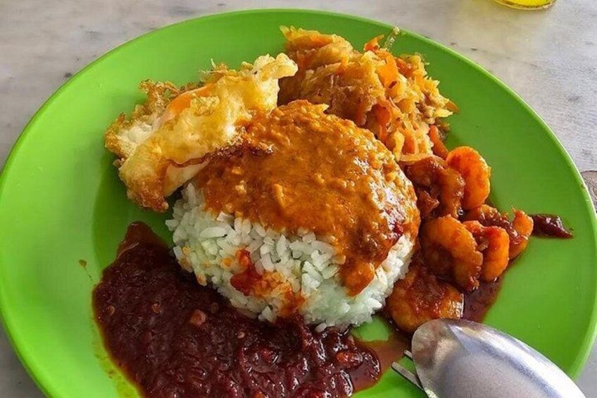 A plate of food with rice, a fried item, and a red sauce. 3