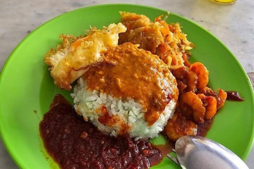 A plate of food with rice, a fried item, and a red sauce. 3