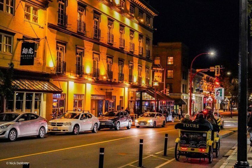 A nighttime street scene with cars, a yellow taxi, and illuminated buildings. 1