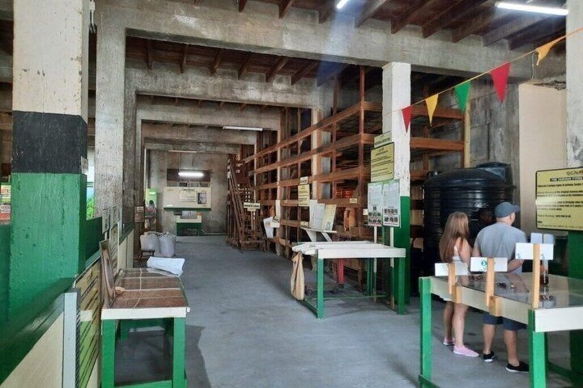 An indoor storage area with shelves, tables, and a large black tank. 5