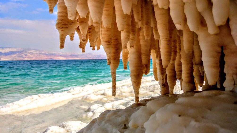 Ice formations at a coastal location with a view of the sea and distant land. 4